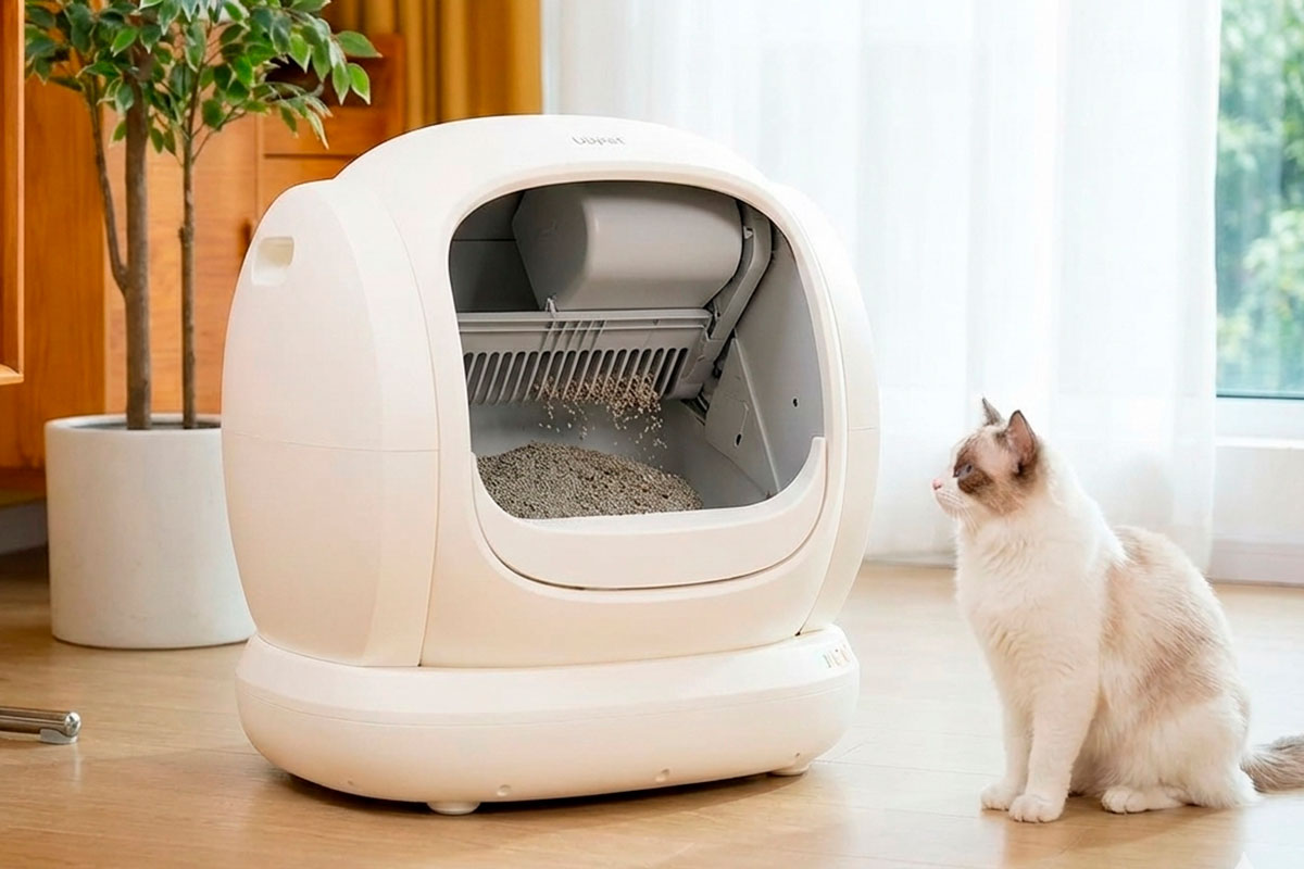 Arenero autolimpiable UBPET C20 con su mecanismo de rastrillo activo tamizando la arena mientras un gato observa.